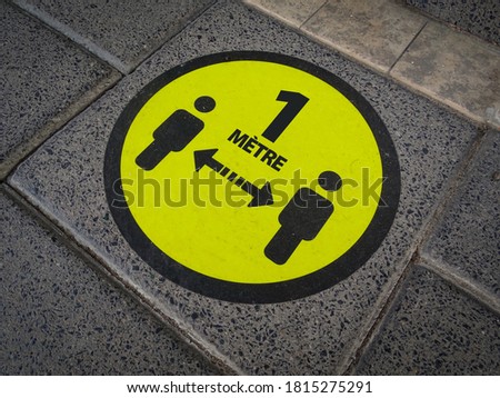 Keep 1 meter (Français 1 mètre) distance symbol. Yellow floor sticker on pavement. Social distancing sign for COVID-19 in pandemic / epidemic crisis time of Corona in France, Paris. Royalty-Free Stock Photo #1815275291