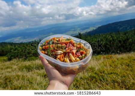 lunch box with healthy vegetarian salad in women hand in the mountains Royalty-Free Stock Photo #1815286643