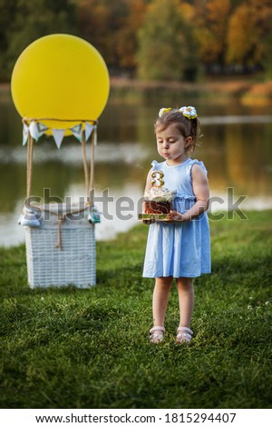 Little girl with a cake in the autumn park.