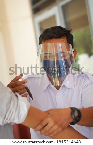 The doctor injects the vaccine into the patient's arm