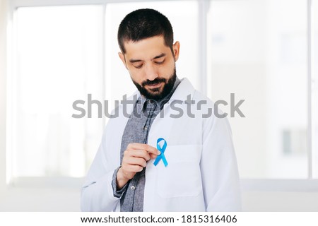 Prostate Cancer Awareness. Doctor man holding light Blue Ribbon for supporting people living and illness. Men Healthcare and World cancer day concept Royalty-Free Stock Photo #1815316406