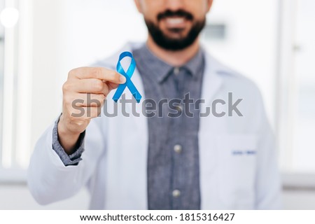 Prostate Cancer Awareness. Doctor man holding light Blue Ribbon for supporting people living and illness. Men Healthcare and World cancer day concept Royalty-Free Stock Photo #1815316427