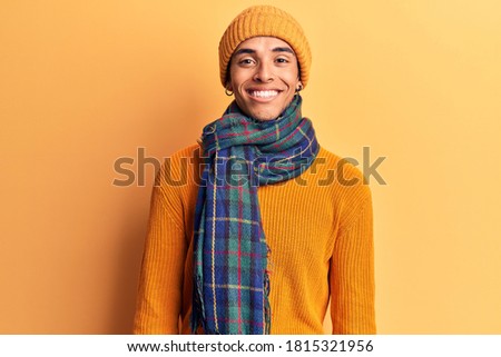 Young african amercian man wearing casual winter clothes looking positive and happy standing and smiling with a confident smile showing teeth 