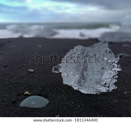 a piece of ice on the black sand