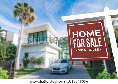 Home For Sale and Open House Real Estate Sign in front of a contemporary minimalist house in a tropical setting.