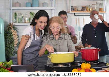 Happy daughter, son or couples and mother and father cooks a organic homemade meal in a family kitchen together with smile