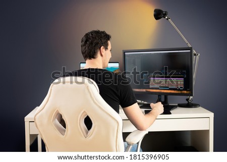 freelance video editor sit on white chair and desk in his office and cut some video footage with graphic tablet