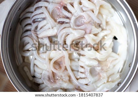 Blurred picture of squid cleaning for cook in kitchen. octopus or cuttlefish in steam pot. selective focus