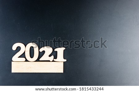 Happy New year 2021 celebration. Numeral 2021 on a dark carbon background. The inscription Postcard for Christmas or New Year.