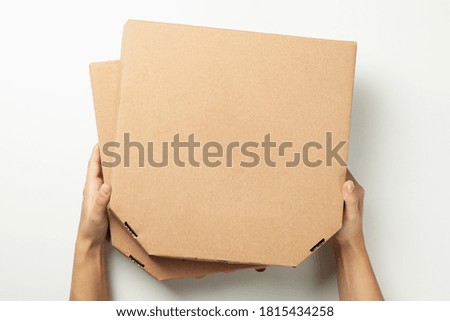 Hands hold boxes with tasty pizza, top view
