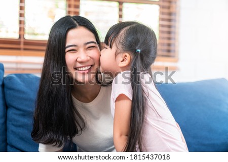 Portrait of young cute asian adorable toddler kiss mom cheek at home smiling happy positive in motherhood concept. Happy family with two people or single mom and little daughter bonding and love.
