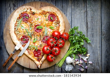 Pizza heart shape with cheese and tomato on vintage boards