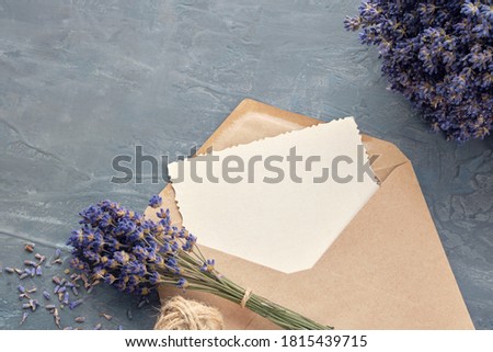 Greeting card and lavender flower bouquets on gray background. Flat lay. 