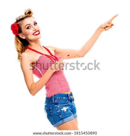 Portrait image amazed happy woman pointing at something. Excited girl in pin up style showing advertising copy space for some ad advertisement text. Retro fashion vintage. Isolated over white. Square.