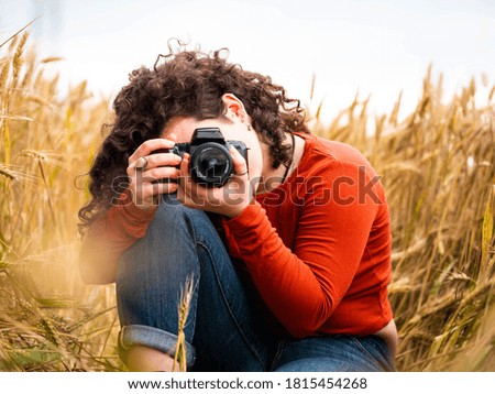 A shallow focus shot of a beautiful young female with a professional photo camera