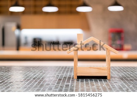Miniature wooden houses and blur light in the background. Buying the first dream house with a young family. Affordable and Eco housing business. Residential and Real Estate development.