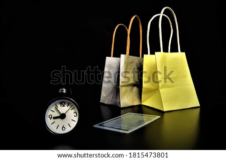 Black friday concept on black background.
 Multi-colored gift bags in a woman's hand on a black background