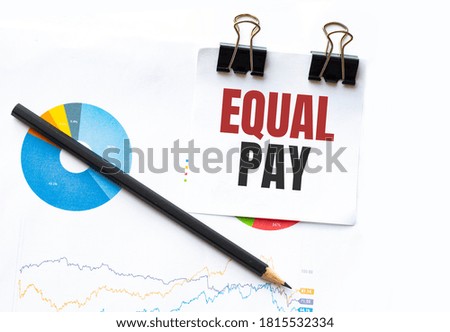 Notepad with text EQUAL PAY on business charts and pen