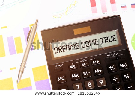 Word DREAMS COME TRUE on calculator. Business and tax concept