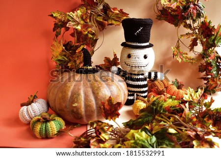 Halloween crochet with cute ghost, pumpkins, spiders, witch hat, knitting, handmade, kid, childhood, children, funny, toys in orange/ autumn leaves background