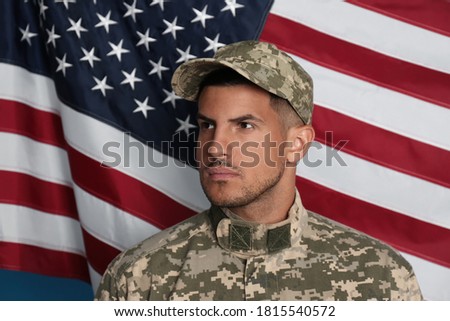 Soldier in uniform and United states of America flag on background