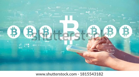 Bitcoin theme with person holding a white smartphone