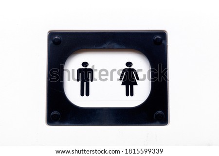 Icons of man and woman on the door of a white walled public toilet.