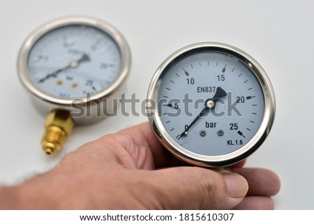 Hand holding a glycerin manometer