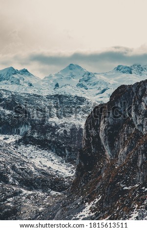 A close up of the snowed mountain range during winter with clouds