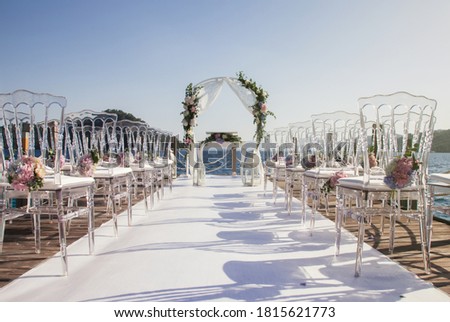 Magnificent design of wedding ceremony on coast of azure sea. Arch for newlyweds marriage registration in modern style. Venue of luxury wedding with amazing landscape. Copyright space for site