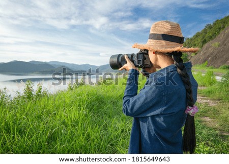 Female photographer, taking pictures of mountain landscape.