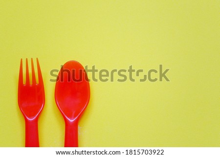 Plastic spoon and fork placed on a bright background and have copy space for design in your work.