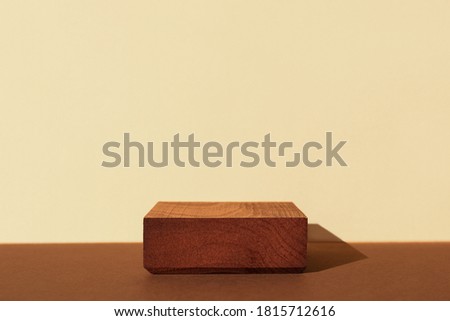 Horizontal template for mockup, banner. Wooden pedestal on brown beige background. Flat square stand or podium for natural design concept. Center composition, hard light, front view