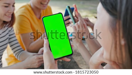 green screen concept - happy young asian students use smartphone on campus