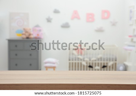 Empty wooden table in baby room. Space for text Royalty-Free Stock Photo #1815725075
