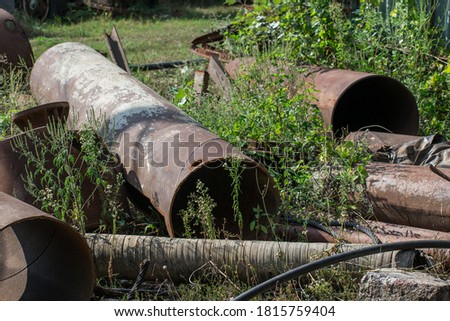 Abandoned rusty pipes in a field. Pipes and other rusty metal elements