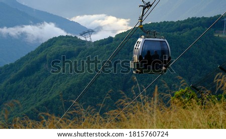 Cable car or gondola to mountain peak. Aerial view of Roza Khutor with traditional cable car above the city, in Sochi, Russia. Rosa Khutor. Nature. Green. Mountains