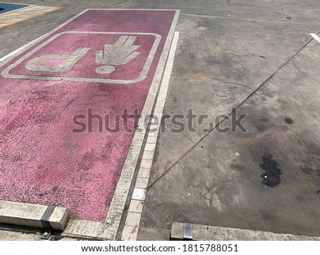The pink symbol on the floor of the parking lot is a parking spot for women.