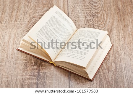 open book lying on a wooden table Royalty-Free Stock Photo #181579583