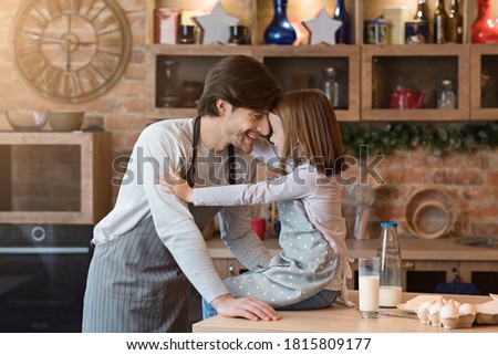 Joyful Young Father Bonding With His Daughter While Cooking In Kitchen Together, Touching Foreheads, Having Fun At Home, Baking Homemade Pastry, Wearing Aprons, Celebrating Father's Day, Copy Space