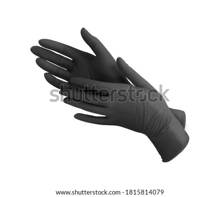 Medical nitrile gloves.Two black surgical gloves isolated on white background with hands. Rubber glove manufacturing, human hand is wearing a latex glove. Doctor or nurse putting on protective gloves Royalty-Free Stock Photo #1815814079