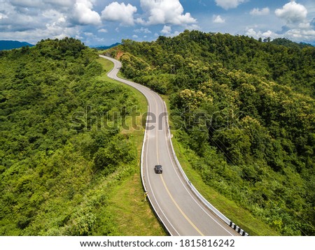 Aerial view of car driving on beautiful steep curved road (look like number 3) on the high mountain in Nan province, Thailand. Royalty-Free Stock Photo #1815816242