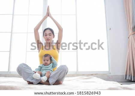 Asian mother fit and play Yoga for lose weight after delivery a new born baby in home, sports mother is engaged in fitness mom, mother, exercise and healthy concept. Royalty-Free Stock Photo #1815826943