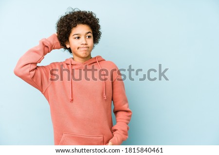 African american little boy isolated touching back of head, thinking and making a choice.