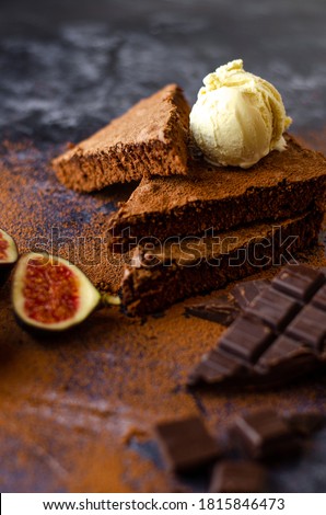Swedish Sticky Chocolate Cake Kladdkaka with Vanilla Ice cream, Figs and dark chocolate on a Dark Stone background