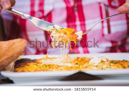 Baked eggs with melted cheese, man eating