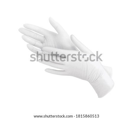 Two white surgical gloves isolated on white background with hands. Medical nitrile gloves. Rubber glove manufacturing, human hand is wearing a latex glove. Doctor or nurse putting on protective gloves Royalty-Free Stock Photo #1815860513