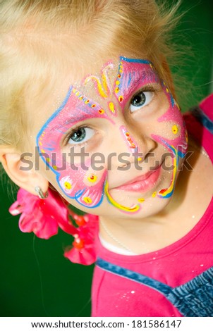 Beautiful girl with blue eyes with painted butterfly on her face