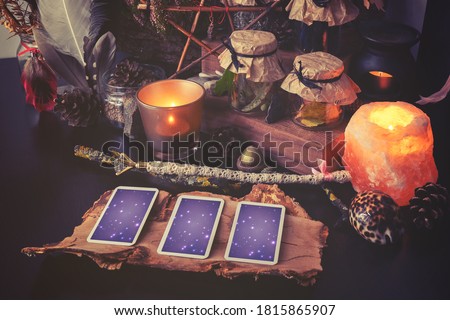 3 Tarot cards spread lying on a black table with magic items. Toned to cold colors in shadows. Royalty-Free Stock Photo #1815865907