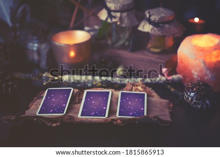 3 Tarot cards spread lying on a black table with magic items. Toned to cold colors in shadows. Royalty-Free Stock Photo #1815865913